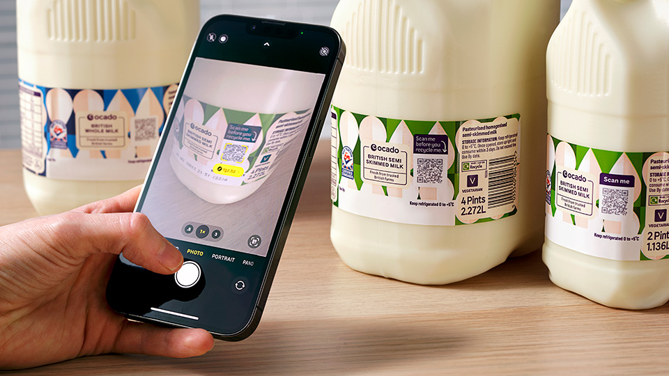 Smartphone scanning the QR code of a bottle of milk.